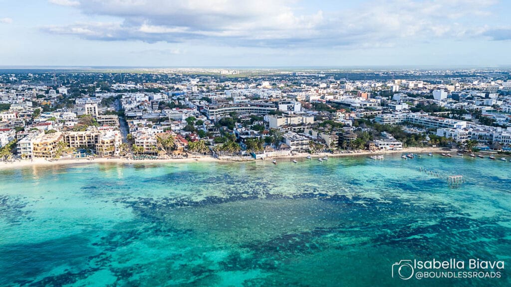 Aerial view of city by turquoise sea.