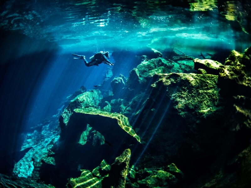 scuba diver exploring underwater cenotes