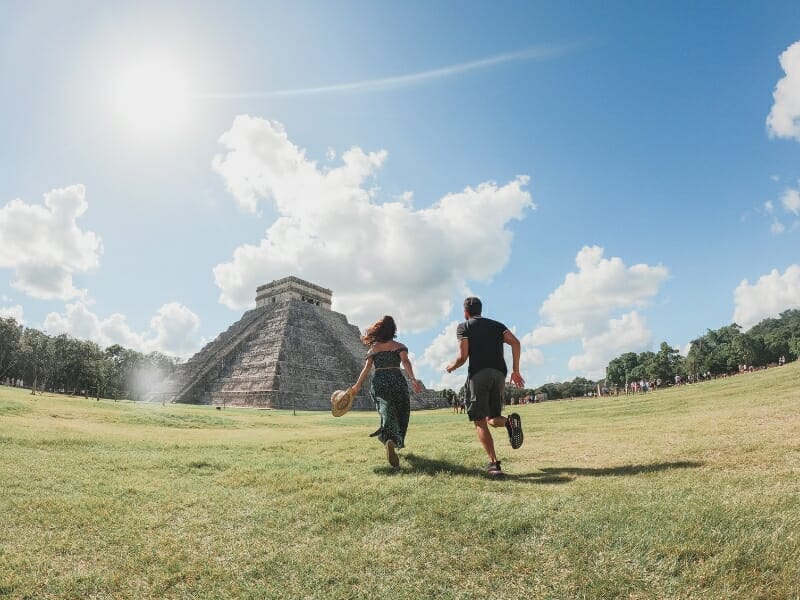 Couple running towards Chichen Itza