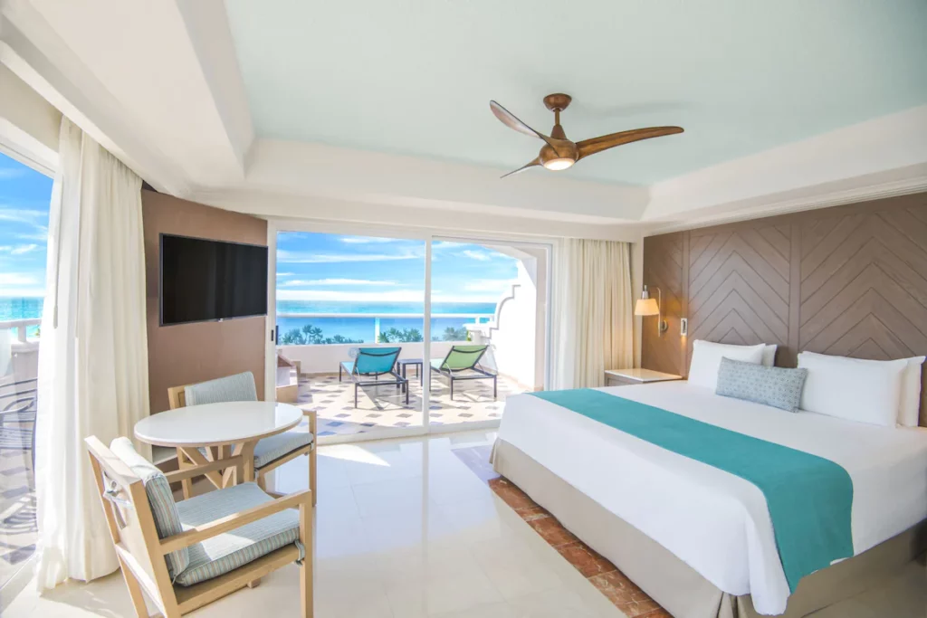 hotel room at Panama Jacks Resorts with table and chairs and terrace with sun chairs overlooking the water