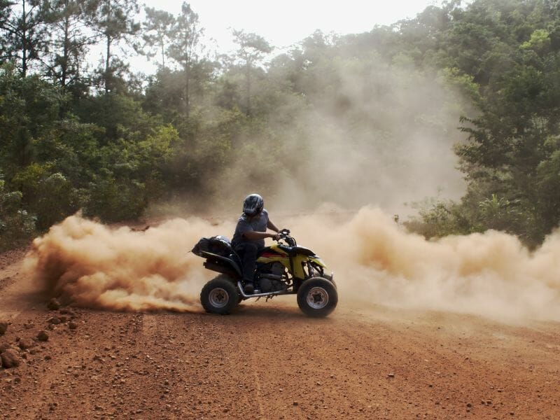 An ATV rider drifting and making huge smoke of sand on one of the ATV tours in Cancun.