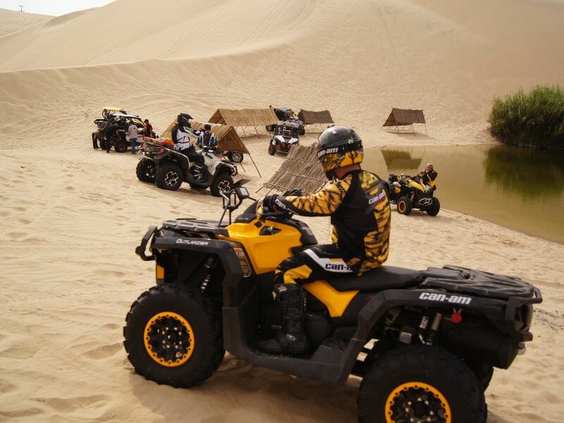A group of ATV riders on a desert-like field in Cancun.