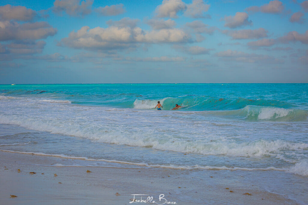 isla blanca guys swimming into waves