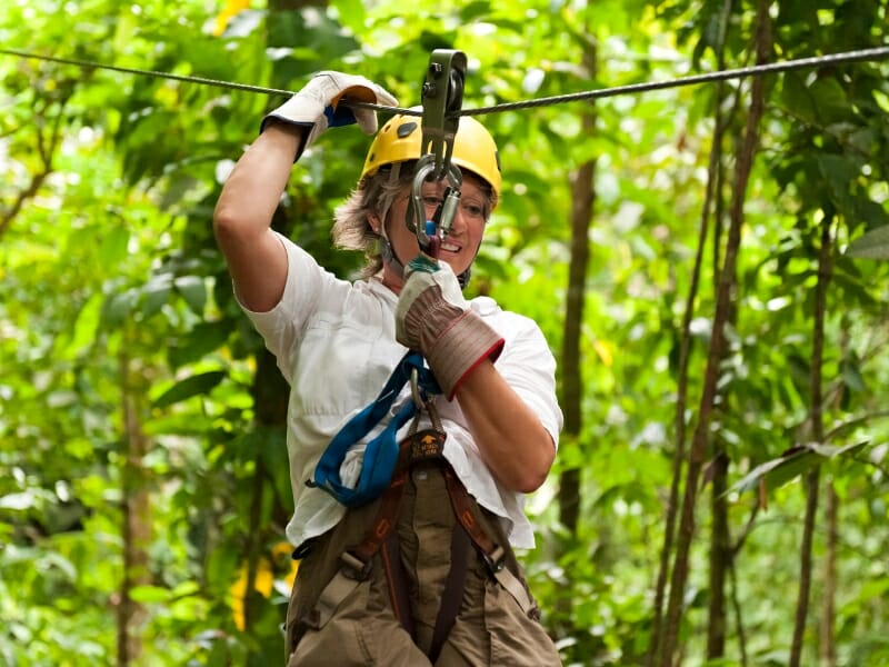 woman ziplining in the jungle