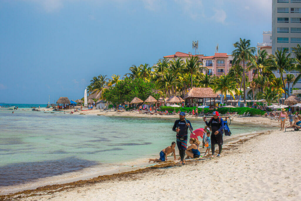 Cancun Beach with white sand filled with people - check out the Cancun hotel zone and find out all the needed information for your visit.