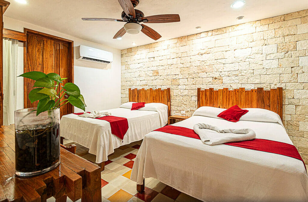 Room at Boutique Casa Hipil with two double beds and stone wall