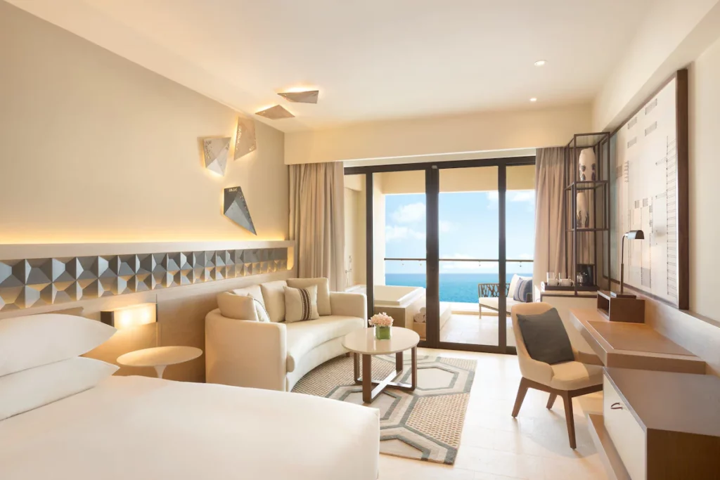 Room with double bed, coucha and balcony overlooking the ocean