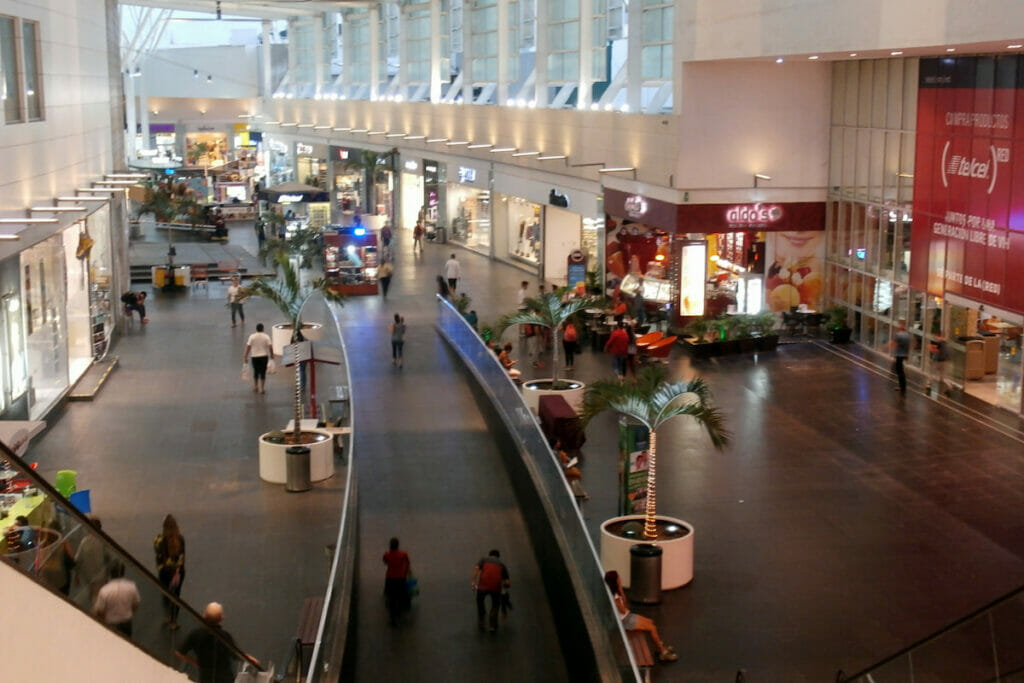 View of the shops, escalator and visitors at Plaza las Americas Cancun.