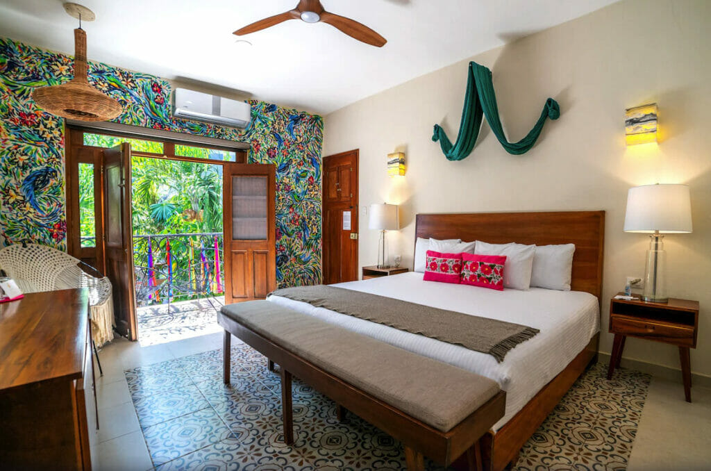 Room at le Muuch Hotel, with double bed terrace and colorful wall.