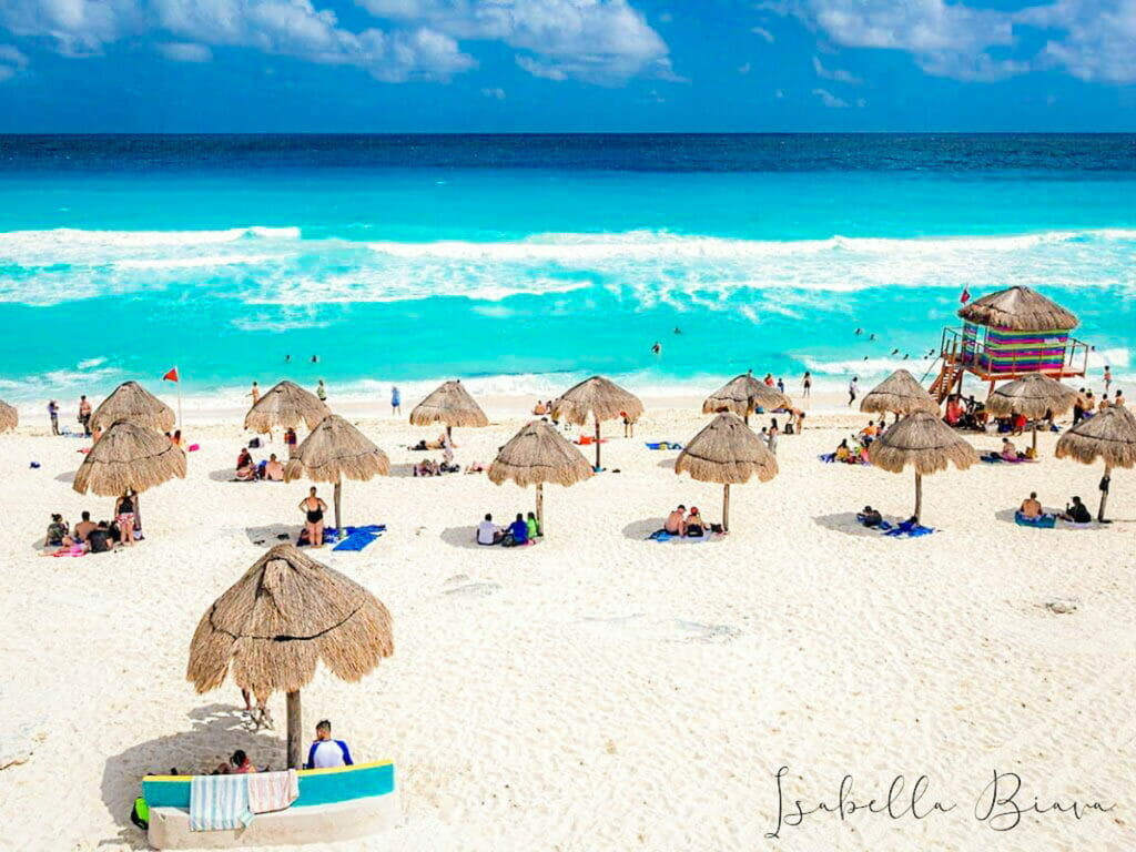 Playa Delfines shore with white sand and turquoise water and huts - adventurous things to do in Cancun.