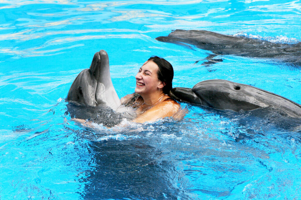 woman playing with a dolphin