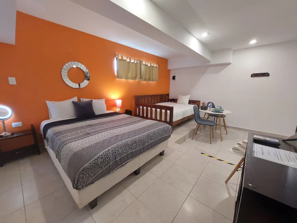 Cancun Suites Apartment room with an orange wall.