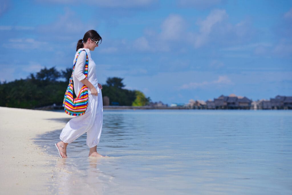 Woman walking on tropical beach shore