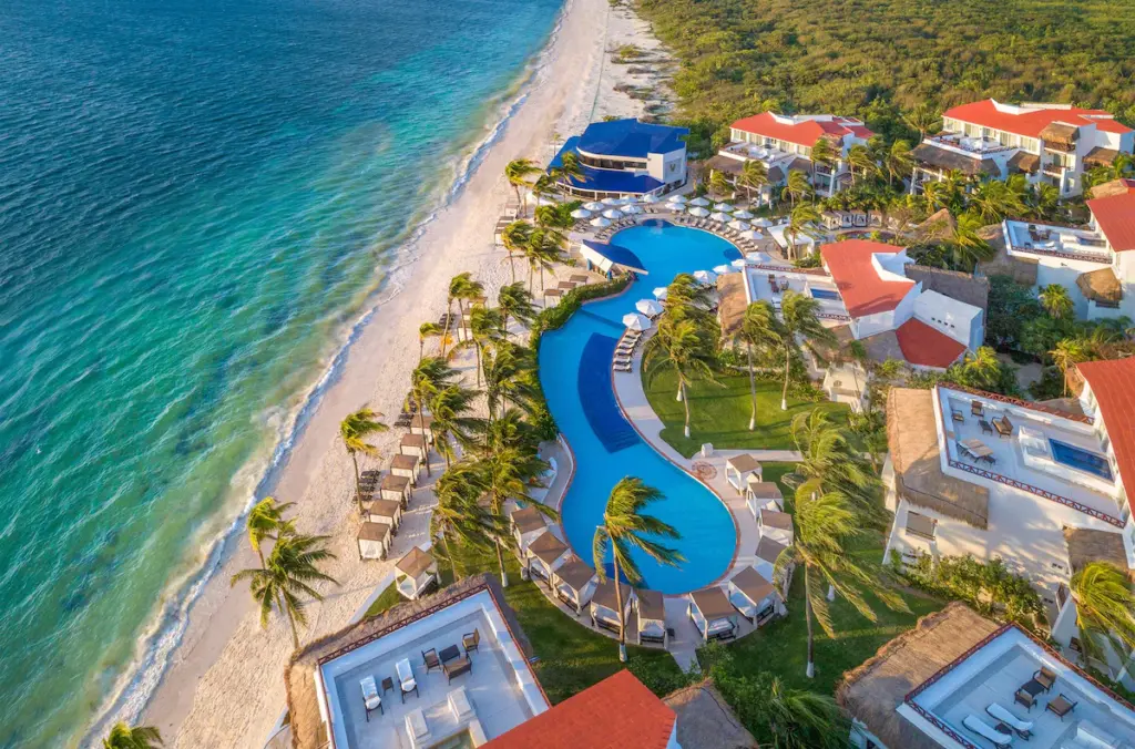 Aerial view of beachfront resort with pool.