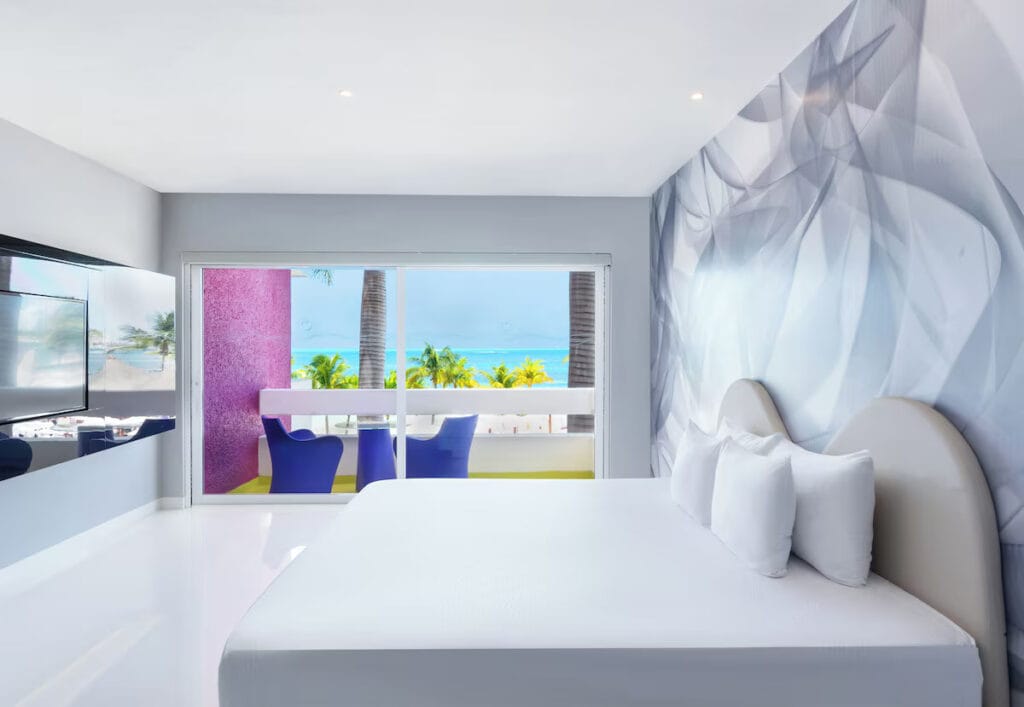 Modern hotel room with ocean view balcony.